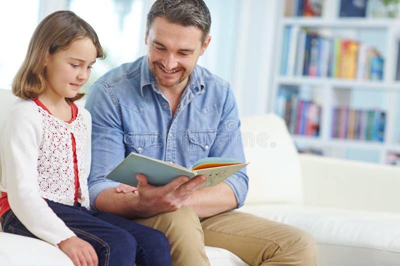 Lernen oder Lesen mit Vater und Tochter auf dem Sofa im Wohnzimmer gemeinsam buchen oder studieren. Bildung lizenzfreie stockbilder