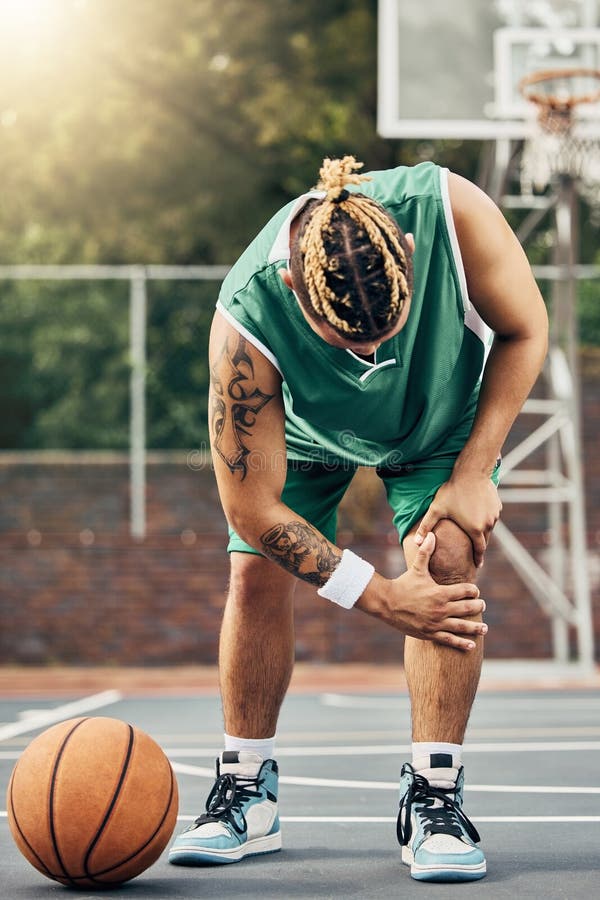 Criança de lesão no joelho de basquete com o pai colocou band-aid