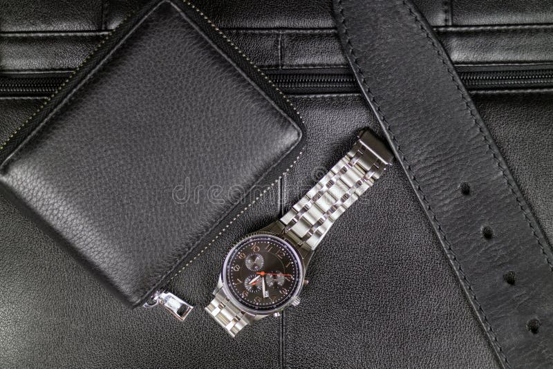 Les accessoires élégants des hommes du cuir noir, du portefeuille, de la ceinture et d'une montre en acier sur le fond d'une serv images libres de droits Les accessoires élégants des hommes du cuir noir, du portefeuille, de la ceinture et d'une montre en acier sur le fond d'une serv images libres de droits