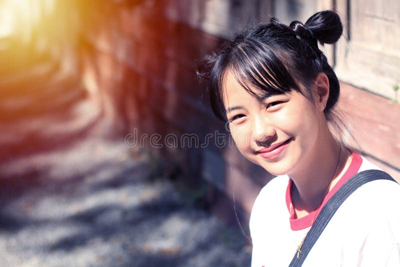 Les adolescentes asiatiques font le lien de cheveux, deux tétines sourient photo libre de droits Les adolescentes asiatiques font le lien de cheveux, deux tétines sourient photo libre de droits