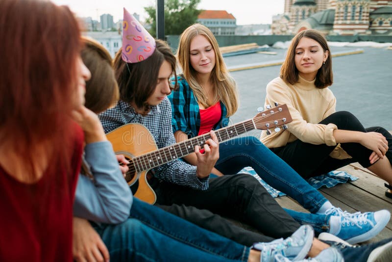 Les amis écoutent des loisirs d'art de jeu de musicien de musicien de rue images stock Les amis écoutent des loisirs d'art de jeu de musicien de musicien de rue images stock