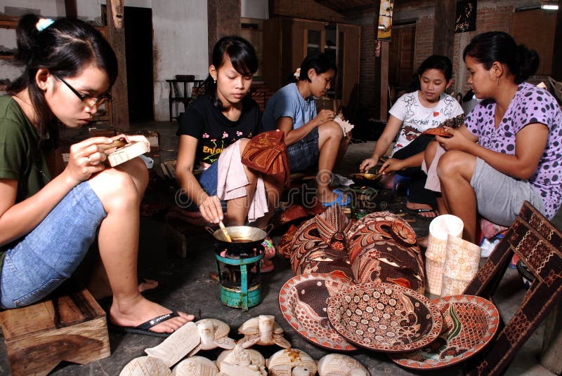 Les artisans de batik ont découpé des motifs de batik sur le bois photo libre de droits Les artisans de batik ont découpé des motifs de batik sur le bois photo libre de droits