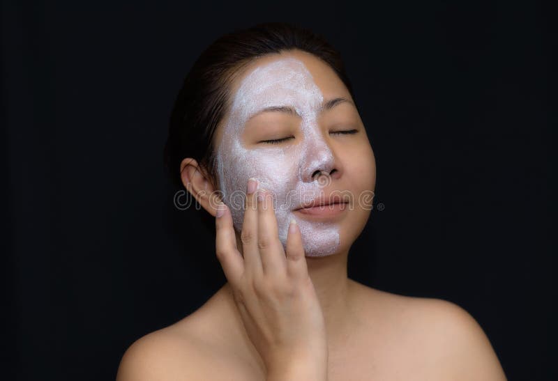 A middle-aged woman Asians are happy with a face mask for skin care.The concept of skin care and beauty. A middle-aged woman Asians are happy with a face mask for skin care.The concept of skin care and beauty.