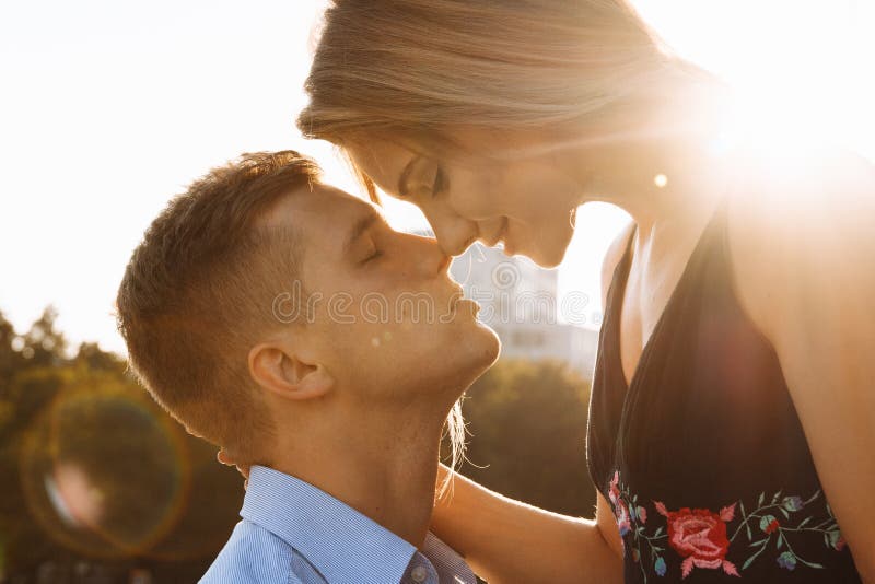 Les baisers de couples, et entre eux les rayons du soleil, le soleil, la lumière attraction entre un homme et une femme baiser photographie stock libre de droits