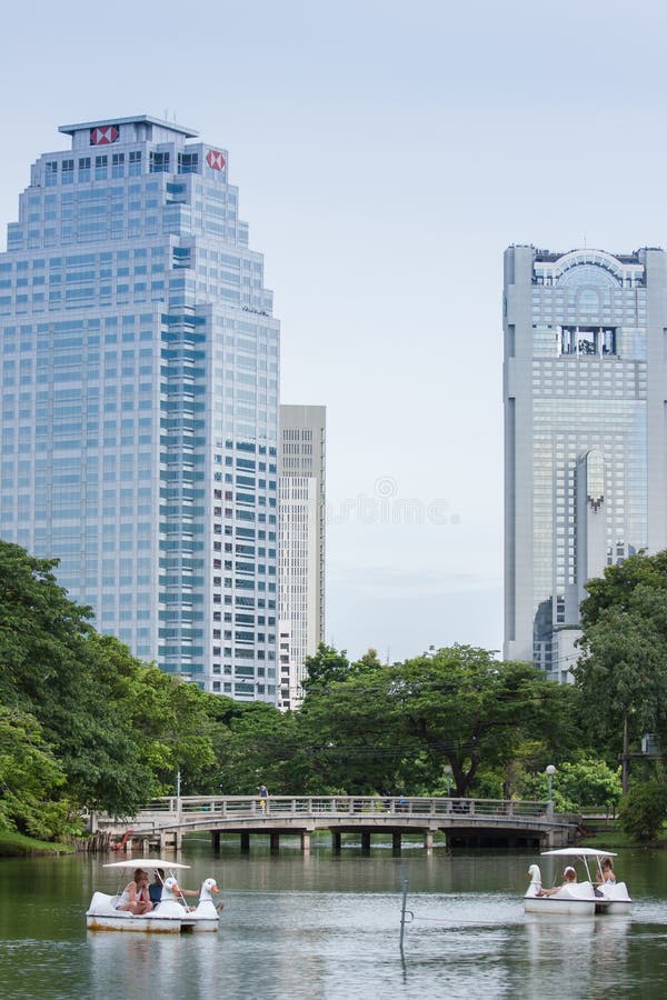Bangkok, Thailand - August 1, 2015: Swan Boats in Lumpini Park with skyscrapers in the background. Bangkok, Thailand - August 1, 2015: Swan Boats in Lumpini Park with skyscrapers in the background.