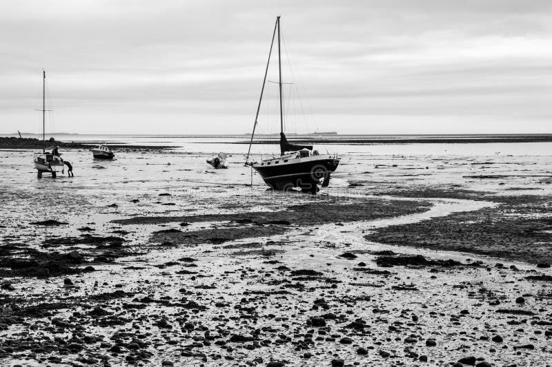 High contrast monochrome image of boats on the foreshore at Lindisfarne Island, Northumberland. High contrast monochrome image of boats on the foreshore at Lindisfarne Island, Northumberland