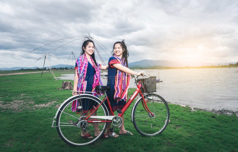 Les belles filles asiatiques apprécient le voyage par la monte sur la bicyclette photo stock Les belles filles asiatiques apprécient le voyage par la monte sur la bicyclette photo stock