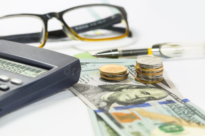 Les billets d'un dollar, stylo, pièces, verres, graphiques de gestion sont tous sur la table image stock Les billets d'un dollar, stylo, pièces, verres, graphiques de gestion sont tous sur la table image stock