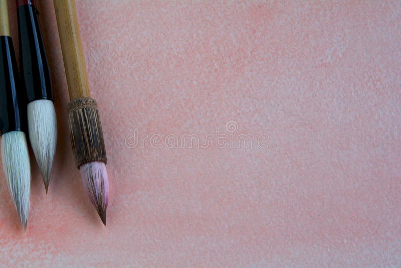 Les brosses chinoises d'aquarelle sur a rose-ont teinté la feuille d'aquarelle ornée avec les wildflowers pourpres photographie stock libre de droits Les brosses chinoises d'aquarelle sur a rose-ont teinté la feuille d'aquarelle ornée avec les wildflowers pourpres photographie stock libre de droits