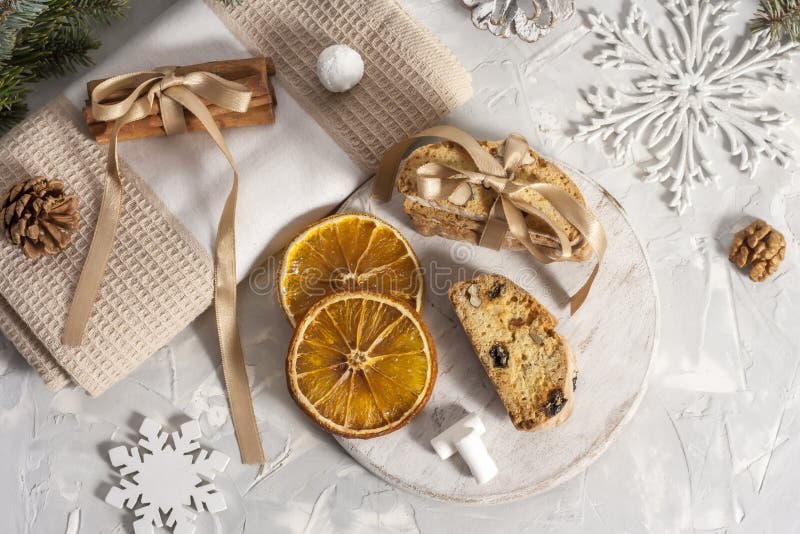 Les bâtons de cannelle sont noués avec un ruban sur une serviette beige avec des tranches d'orange séché, de cône de pin, de noix photographie stock Les bâtons de cannelle sont noués avec un ruban sur une serviette beige avec des tranches d'orange séché, de cône de pin, de noix photographie stock