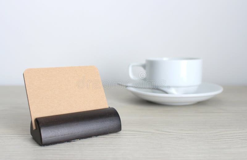 Les cartes de visite professionnelle de visite et la tasse de café vides sur le bureau en bois ajournent des WI photos stock Les cartes de visite professionnelle de visite et la tasse de café vides sur le bureau en bois ajournent des WI photos stock