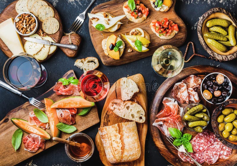 Les casse-croûte italiens de vin d'antipasti ont placé au-dessus du fond grunge noir images stock Les casse-croûte italiens de vin d'antipasti ont placé au-dessus du fond grunge noir images stock