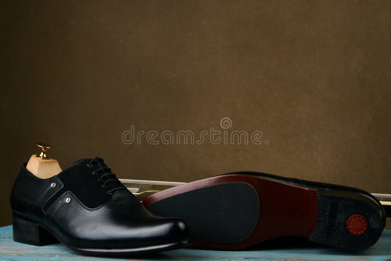 Les chaussures et la guitare basse des hommes en cuir au-dessus du fond brun avec l'espace de copie image libre de droits Les chaussures et la guitare basse des hommes en cuir au-dessus du fond brun avec l'espace de copie image libre de droits