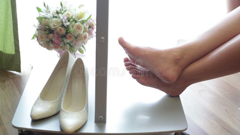 Les chaussures et le bouquet nuptiale de la femme