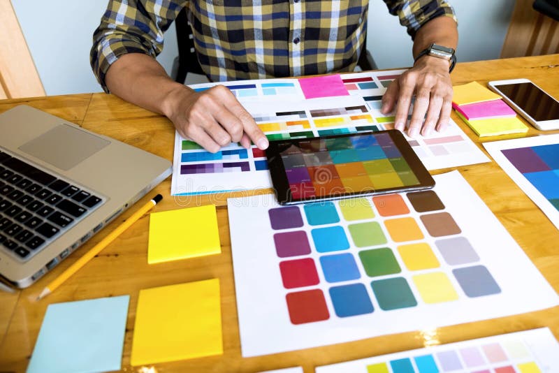 Les concepteurs utilisent le comprimé pour choisir des couleurs de l'exemple de discrimination raciale pour les idées de concepti photo stock Les concepteurs utilisent le comprimé pour choisir des couleurs de l'exemple de discrimination raciale pour les idées de concepti photo stock