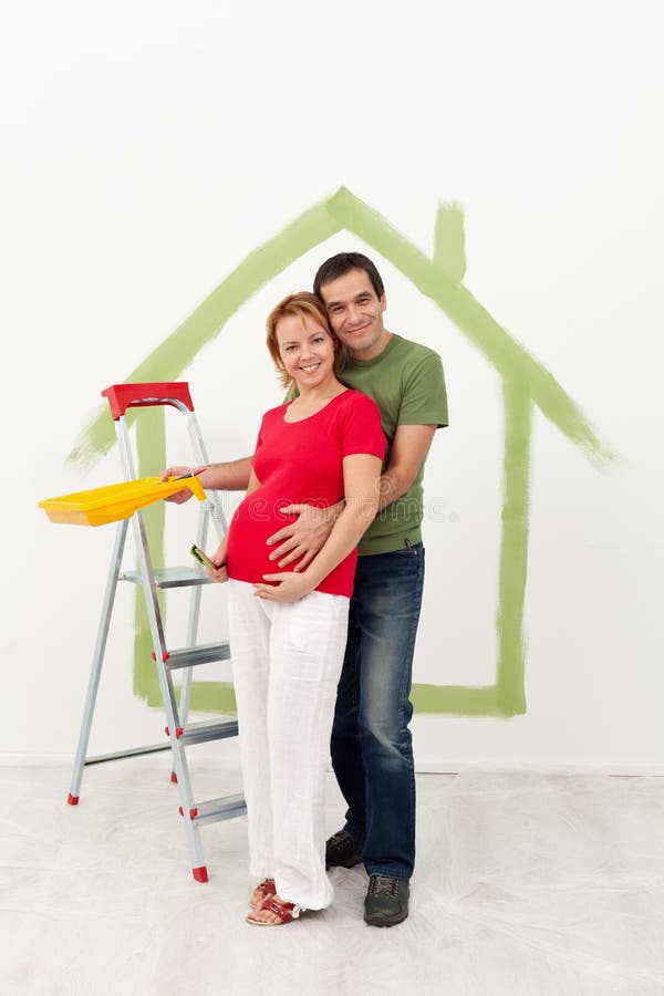 Les couples attendant un bébé refont leur nouvelle maison image stock Les couples attendant un bébé refont leur nouvelle maison image stock
