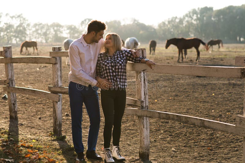 Les couples dans l'amour apprécient le jour dans la nature et les chevaux image libre de droits Les couples dans l'amour apprécient le jour dans la nature et les chevaux image libre de droits