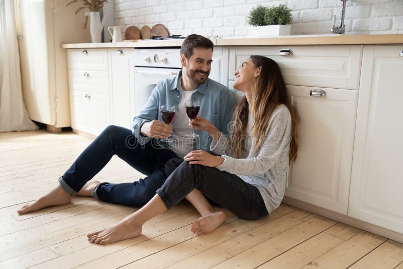 Les couples heureux sont assis sur le sol ayant la date romantique à la maison photos libres de droits