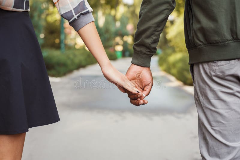 Les couples multi-ethniques dans l'amour marchent en plan rapproché de parc images libres de droits Les couples multi-ethniques dans l'amour marchent en plan rapproché de parc images libres de droits