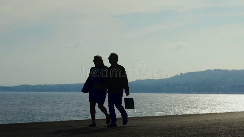 Les couples romantiques appréciant le jour promenade à Nice, athlète courant sur le remblai