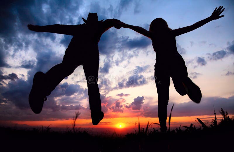 Les couples silhouettent le fonctionnement au coucher du soleil photographie stock Les couples silhouettent le fonctionnement au coucher du soleil photographie stock