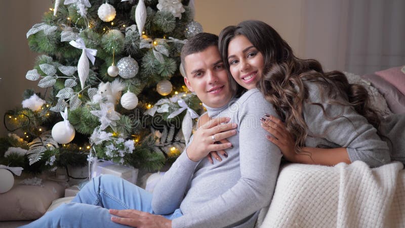 Les couples étreignent à la maison sur l'arbre de sapin de fond, moments romantiques la veille de la nouvelle année