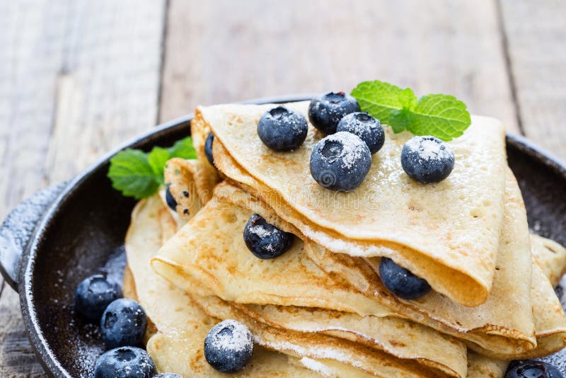 Les crêpes ont servi avec les myrtilles fraîches et ont saupoudré le sucre photos stock Les crêpes ont servi avec les myrtilles fraîches et ont saupoudré le sucre photos stock