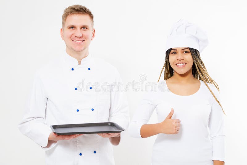 Les cuisinières de femme de couleur de Smule et d'homme blanc tiennent un plateau vide et montrent comme photo stock Les cuisinières de femme de couleur de Smule et d'homme blanc tiennent un plateau vide et montrent comme photo stock