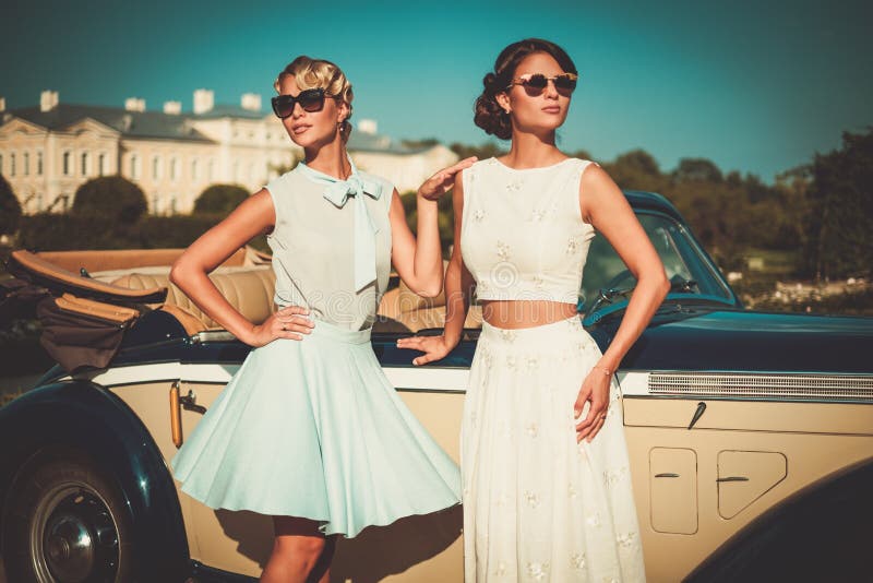 Les dames s'approchent du convertible classique photos stock Les dames s'approchent du convertible classique photos stock