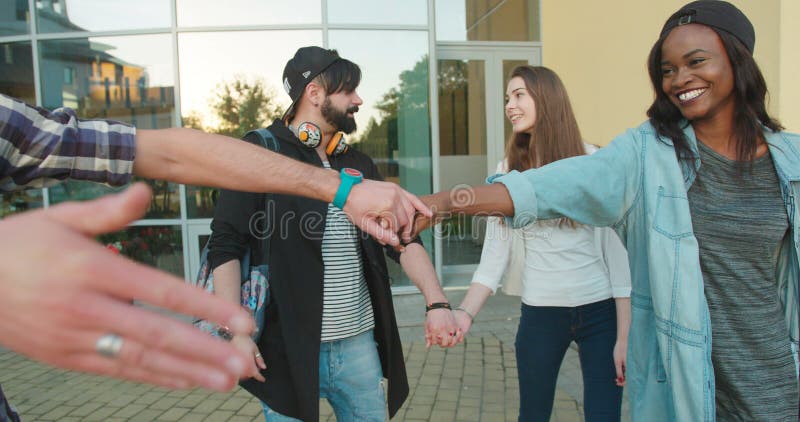 Les deux couples multiculturels heureux de hippie sont dansants et étreignants pendant leur promenade