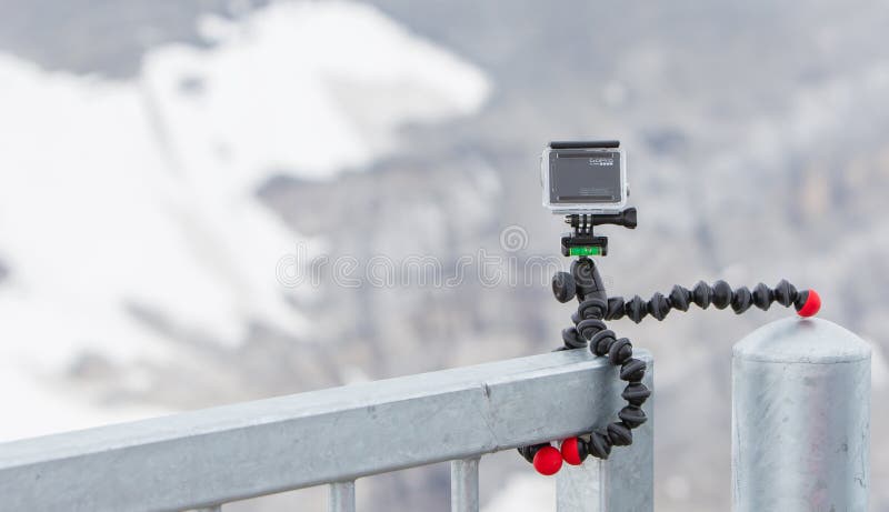 LES DIABLERETS, SWITZERLAND - JULY 22, 2015: Closeup of GoPro Hero 4 camera on GorillaPod tripod in action, filming fast moving clouds.