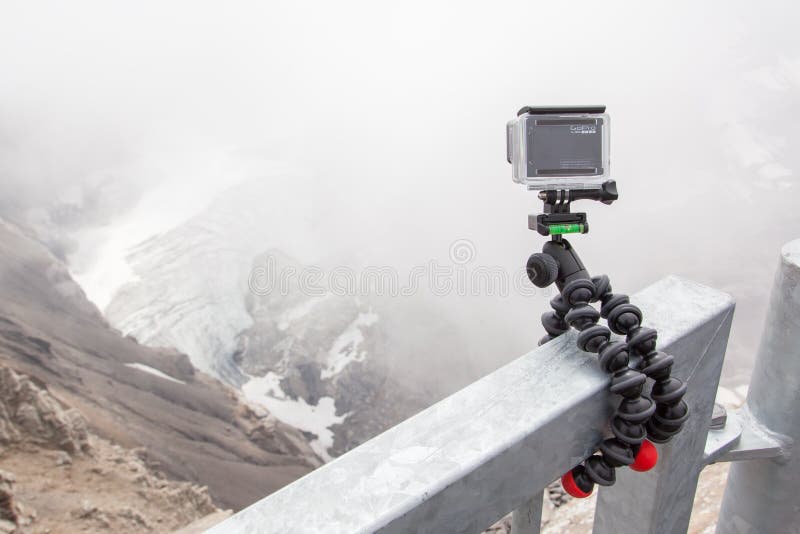 LES DIABLERETS, SWITZERLAND - JULY 22, 2015: Closeup of GoPro Hero 4 camera on GorillaPod tripod in action, filming fast moving clouds.