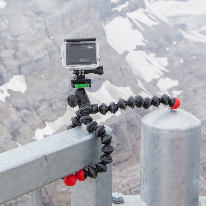 LES DIABLERETS, SWITZERLAND - JULY 22, 2015: Closeup of GoPro Hero 4 camera on GorillaPod tripod in action, filming fast moving clouds.