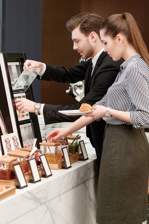Les directeurs commerciaux prennent les croissants et la confiture au images libres de droits Les directeurs commerciaux prennent les croissants et la confiture au images libres de droits