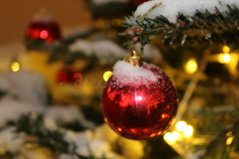 Les décorations de Noël sur l'arbre de Noël en rouge et or colore répandu avec des lumières, plan rapproché image stock Les décorations de Noël sur l'arbre de Noël en rouge et or colore répandu avec des lumières, plan rapproché image stock