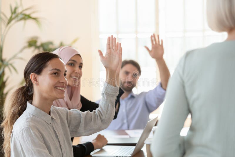 Multicultural young employees gathered together at seminar activity corporate training raise hand vote unanimously all participants agree, Business team election, engagement in volunteering concept. Multicultural young employees gathered together at seminar activity corporate training raise hand vote unanimously all participants agree, Business team election, engagement in volunteering concept