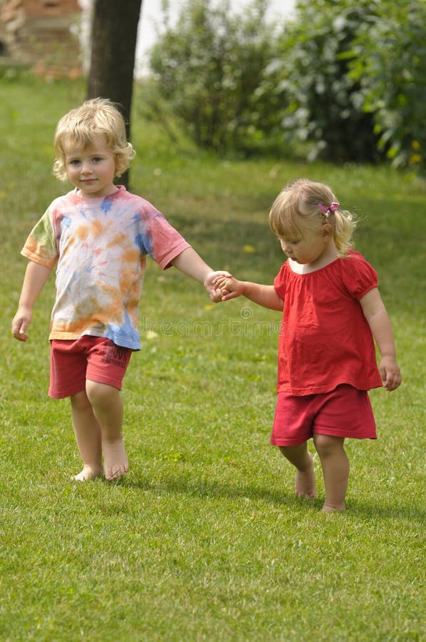 The children holding on the hand, girl in red dress. The children holding on the hand, girl in red dress