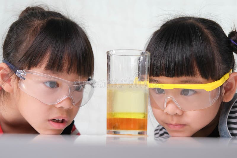 les enfants apprennent et font des expériences scientifiques en classe.  deux petites soeurs jouant à l'expérience scientifique pour l'enseignement  à domicile. des expériences scientifiques faciles et amusantes pour les  enfants à la