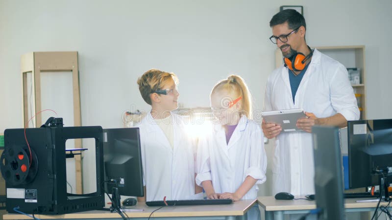 Les enfants de sourire parlent à un technicien de laboratoire adulte