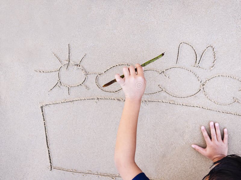 Les enfants dessine la photo sur le fond de vacances d'été de plage de sable images stock Les enfants dessine la photo sur le fond de vacances d'été de plage de sable images stock