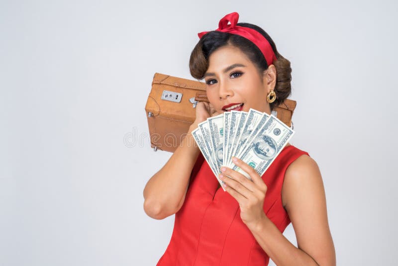 Les femmes rétro de mode remettent prennent un bagage et d'argent en dollars pour voyager photo stock