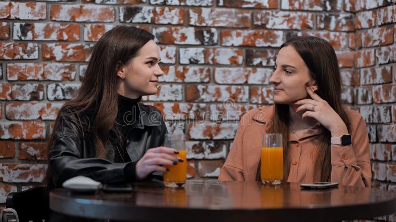 Girls at the cafe drinking orange juice. Girls at the cafe drinking orange juice