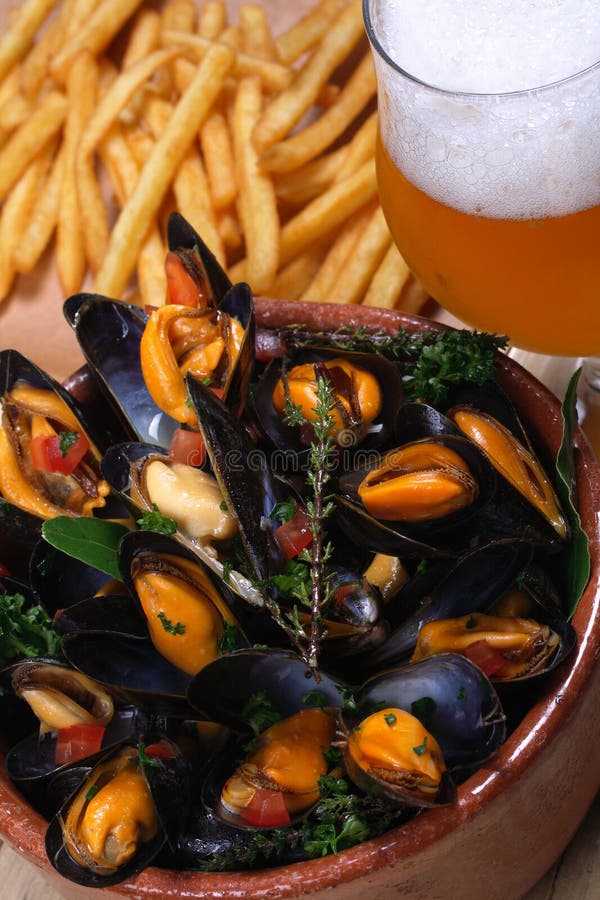 Mussels, cooked in white wine with aromatic herbs from Provence, French fries and a glass of beer. Mussels, cooked in white wine with aromatic herbs from Provence, French fries and a glass of beer