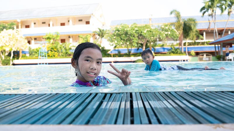 Les garçons et les filles ont l'amusement jouant dans la piscine photo stock Les garçons et les filles ont l'amusement jouant dans la piscine photo stock