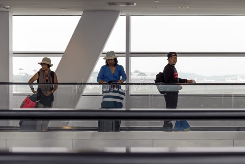 Les gens avec le bagage à l'aéroport sur bande mobile de passager photos libres de droits Les gens avec le bagage à l'aéroport sur bande mobile de passager photos libres de droits