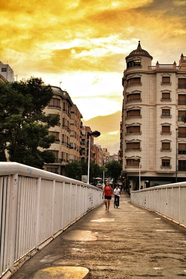 Les gens croisant un pont au coucher du soleil à Elche photos stock Les gens croisant un pont au coucher du soleil à Elche photos stock