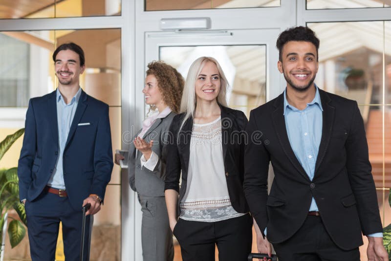 Les gens d'affaires dans le lobby d'hôtel, invités de groupe d'hommes d'affaires de course de mélange arrivent image stock Les gens d'affaires dans le lobby d'hôtel, invités de groupe d'hommes d'affaires de course de mélange arrivent image stock