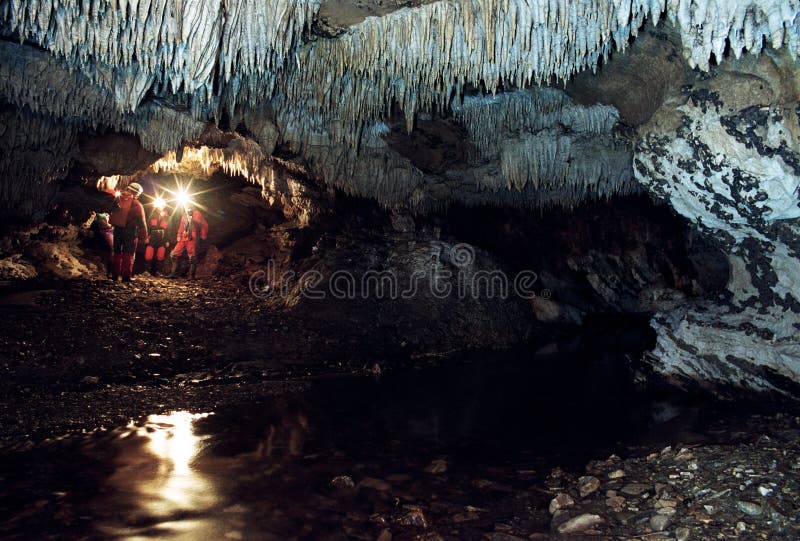 Team of speleologist in the Romania cave Comarnic near the underground river. Team of speleologist in the Romania cave Comarnic near the underground river.