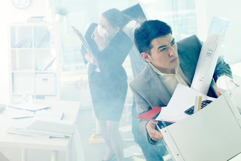 Businessman taking his things out of burning office, keeping cool. Businessman taking his things out of burning office, keeping cool