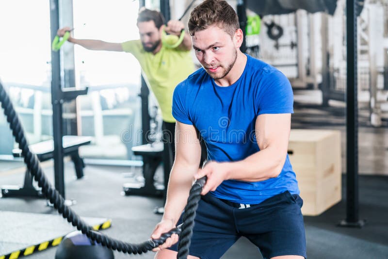 Les gens dans le gymnase faisant le sport dans la formation fonctionnelle de forme physique photo stock Les gens dans le gymnase faisant le sport dans la formation fonctionnelle de forme physique photo stock